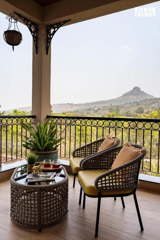 Two chairs and a low table facing a distant hill in soft morning light